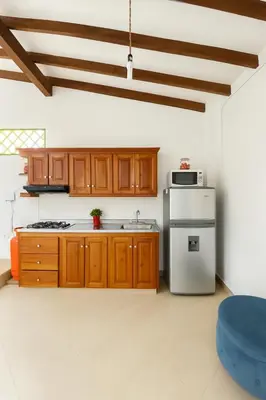 a kitchen with wooden cabinets and a stainless steel refrigerator at Aluna Apartamento Jericó in Jericó