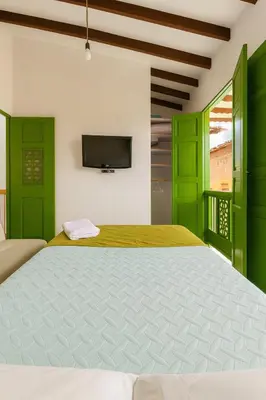 a bedroom with green doors and a large bed at Aluna Apartamento Jericó in Jericó