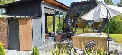 a building with an umbrella in a garden at Cabañas Bosque Verde in Piedra El Marcial