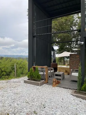 a dog sitting on the gravel outside of a building at Cabañas Bosque Verde in Piedra El Marcial