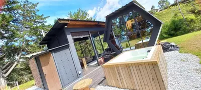 a tiny house with a glass door and a hot tub at Cabañas Bosque Verde in Piedra El Marcial