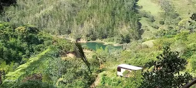 a small building on a hill next to a river at Cabañas Bosque Verde in Piedra El Marcial