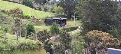 a cabin in the middle of a hill with trees at Cabañas Bosque Verde in Piedra El Marcial