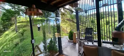 a view from the inside of a house with a glass window at Cabañas Bosque Verde in Piedra El Marcial