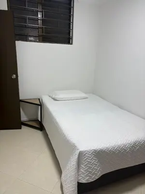 a white bed in a room with a window at Apto en Laureles, 4 Habitaciones Ideal para Grupos in Medellín