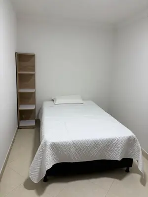 a bed in a white room with a white bedspread at Apto en Laureles, 4 Habitaciones Ideal para Grupos in Medellín