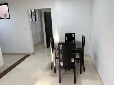 a dining room table with chairs and a laptop on it at Apto en Laureles, 4 Habitaciones Ideal para Grupos in Medellín