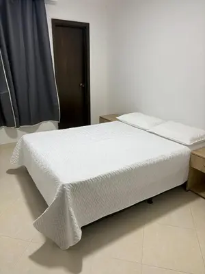 a bed in a room with a white mattress at Apto en Laureles, 4 Habitaciones Ideal para Grupos in Medellín