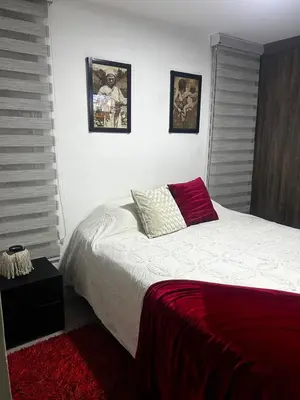 a bedroom with a white bed with a red blanket at Aptosvacacionales Medellín in Medellín