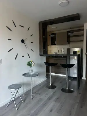 a kitchen with a clock on the wall and stools at Aptosvacacionales Medellín in Medellín