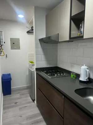 a kitchen with a sink and a stove top oven at Aptosvacacionales Medellín in Medellín