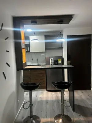 a kitchen with two bar stools and a counter at Aptosvacacionales Medellín in Medellín