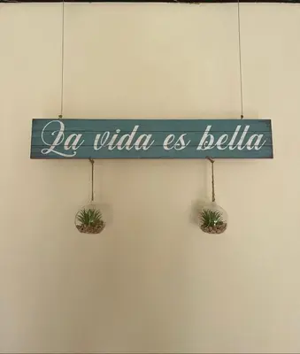 a sign that reads la vida as belloria hanging on a wall at La Vide es Bella in Supía