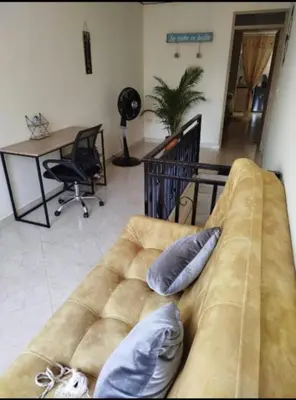 a couch in a living room with two pillows on it at La Vide es Bella in Supía