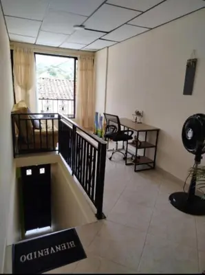 an office with a staircase and a table and a window at La Vide es Bella in Supía