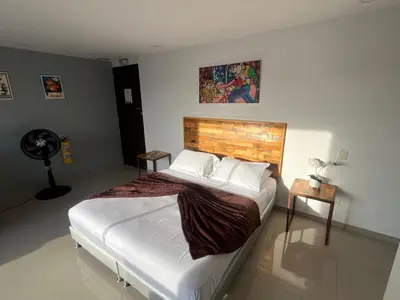 a bedroom with a large bed and a fan at Loft en Medellin El Poblado Vista espectacular in Medellín