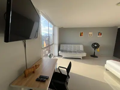 a living room with a television and a couch at Loft en Medellin El Poblado Vista espectacular in Medellín