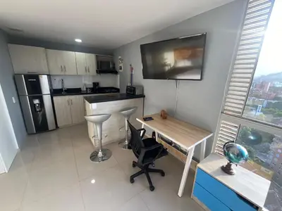 a kitchen with a desk and a table with chairs at Loft en Medellin El Poblado Vista espectacular in Medellín