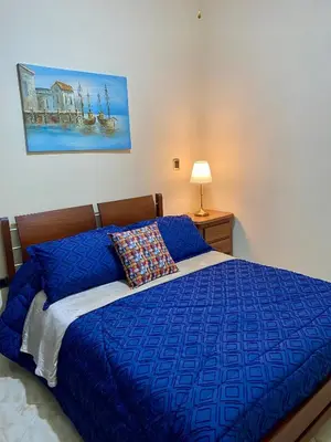 a blue bed with a blue comforter and a pillow at Apartamento Central Envigado in Envigado