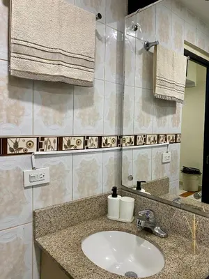 a bathroom with a sink and a mirror and towels at Apartamento Central Envigado in Envigado