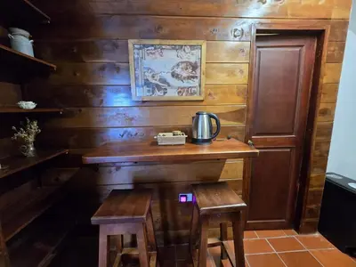 a room with a wooden wall with a table and stool at Luxurious country cabin, BBQ, Jacuzzi, TV, WiFi in Marinilla