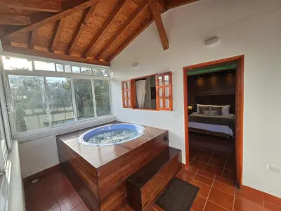 a jacuzzi tub in a room with a bedroom at Luxurious country cabin, BBQ, Jacuzzi, TV, WiFi in Marinilla