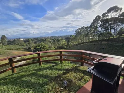 a grill sitting next to a wooden fence at Luxurious country cabin, BBQ, Jacuzzi, TV, WiFi in Marinilla