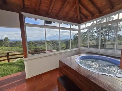 a large room with a hot tub in a room with windows at Luxurious country cabin, BBQ, Jacuzzi, TV, WiFi in Marinilla