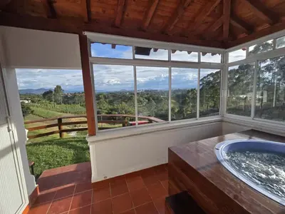 a bathroom with a tub and a large window at Luxurious country cabin, BBQ, Jacuzzi, TV, WiFi in Marinilla