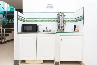 a white kitchen with a microwave and a sink at Hotel Villa Real 70 Laureles in Medellín