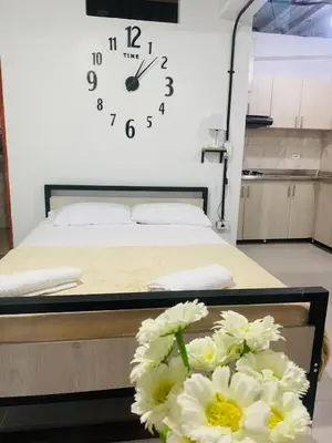 a bedroom with a bed with a clock on the wall at Hotel Curazao Natural Living cerca a charcos naturales y tobogán extremo in Cocorná