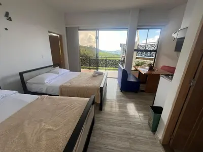 a hotel room with two beds and a balcony at Hotel Curazao Natural Living cerca a charcos naturales y tobogán extremo in Cocorná