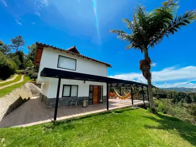 a house on a hill with a palm tree at Apartamento en Guarne-Antioquia in Guarne