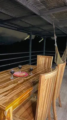 a wooden table with two wine glasses on a deck at Apartamento en Guarne-Antioquia in Guarne