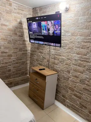 a bedroom with a tv on a brick wall at Apartamento en la mejor zona de buenos aires in Medellín