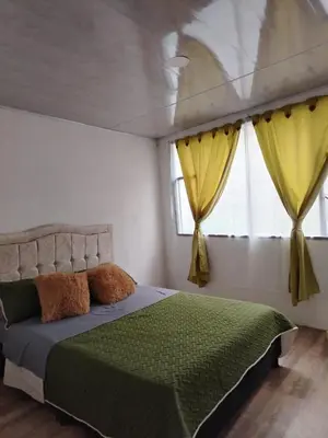 a bedroom with a bed and a window with yellow curtains at Squirrel and bird watching in Fresno