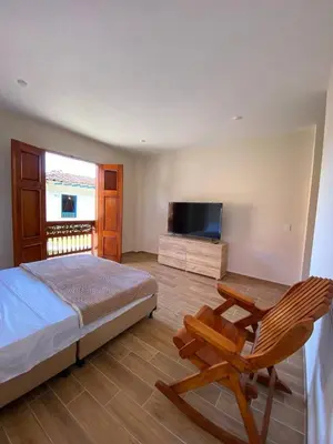 a bedroom with a bed and a chair and a television at Casa Colonial Jericó - Casa Romo in Jericó