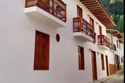 a white building with wooden doors and balconies at Casa Colonial Jericó - Casa Romo in Jericó