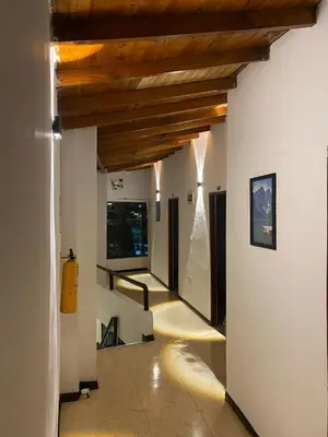 a hallway with wood ceilings and a hallway with stairs at Hotel Galería Plaza in Santa Bárbara