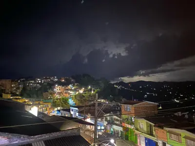 a view of a city at night with a storm at Hotel Galería Plaza in Santa Bárbara