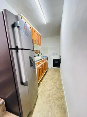 a kitchen with a stainless steel refrigerator and wooden cabinets at Hospedaje Mi casita in Guatapé