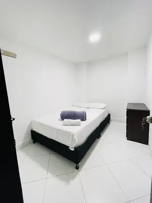 a bedroom with a bed in a white room at Hospedaje Mi casita in Guatapé