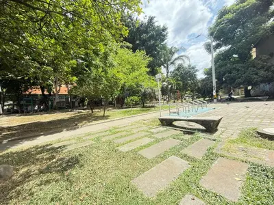 a park with a bench in the grass at Laureles Boutique Stay in Medellín