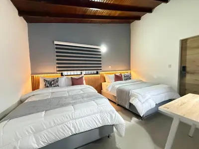 a bedroom with two beds and a table at Laureles Boutique Stay in Medellín