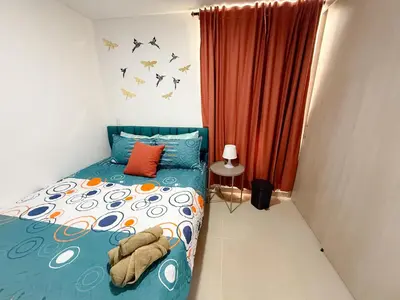 a bedroom with a bed with a blue comforter at Apartamento con vista a la montaña, piscina y gym in Sabaneta