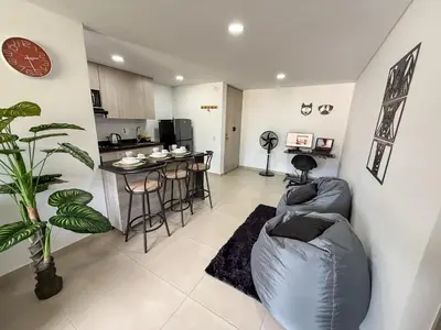 a living room with a couch and a table at Apartamento con vista a la montaña, piscina y gym in Sabaneta