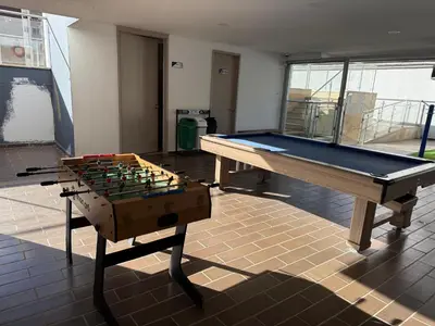 a ping pong table and chessboard in a room at Apartamento con vista a la montaña, piscina y gym in Sabaneta