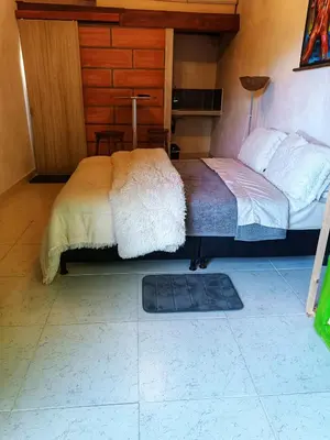 a bedroom with a bed and a rug on the floor at Hotel Marrokos Aeropuerto José María Córdova in Rionegro