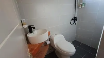 a bathroom with a toilet and a sink at Hotel Marrokos Aeropuerto José María Córdova in Rionegro