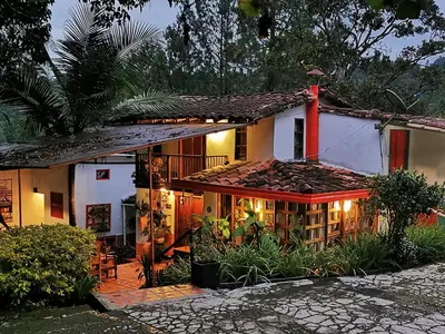 a house with lights on the side of it at Hotel Marrokos Aeropuerto José María Córdova in Rionegro